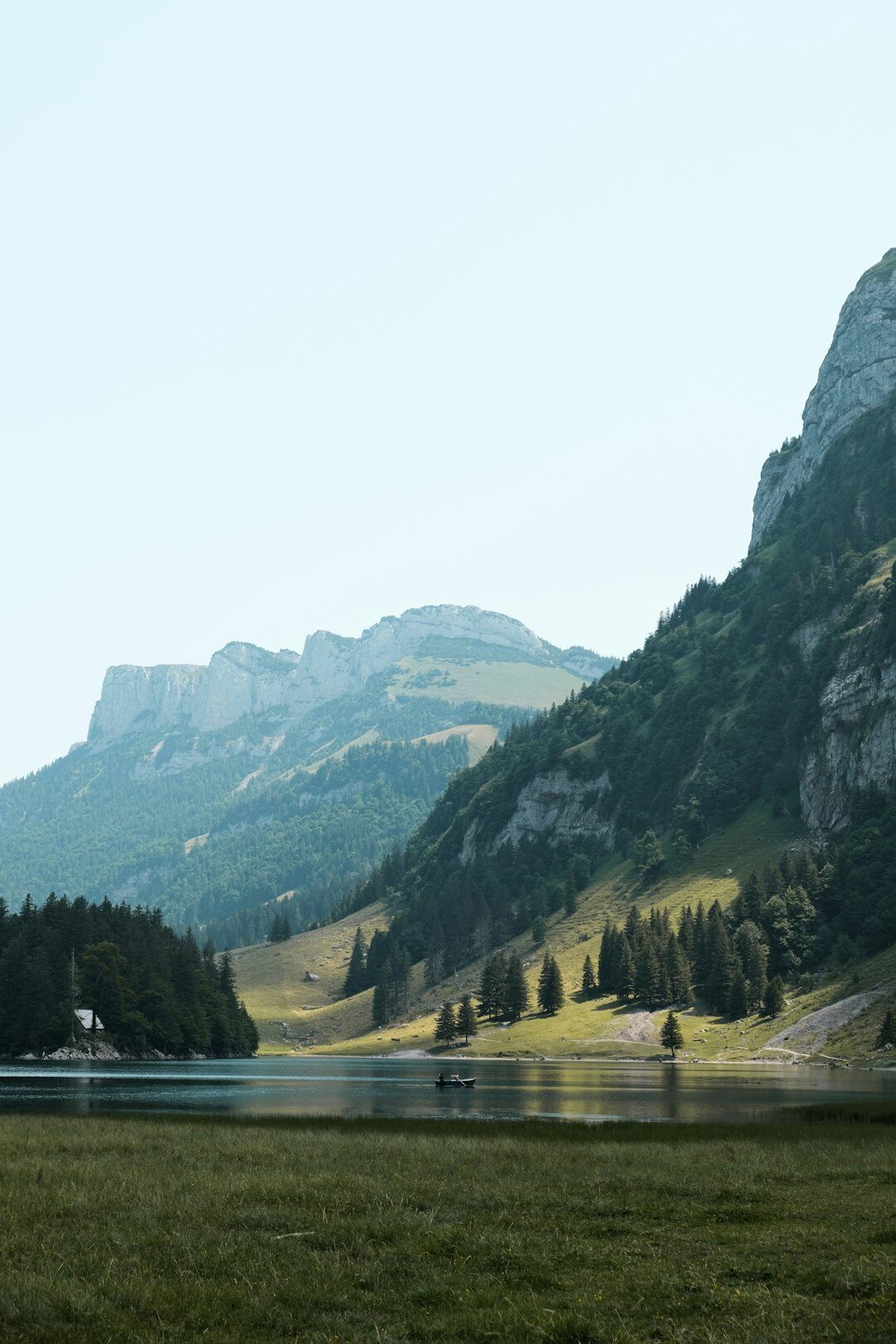 Filmmaker recording a landscape shot near a Swiss lake with mountains in the background